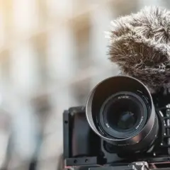 Kamera z obiektywem i futrzanym mikrofonem, idealna do nagrywania dźwięku. Jaki mikrofon do aparatu wybrać?