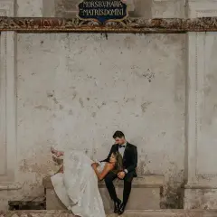 Para młoda w stylizowanych strojach na tle zabytkowych murów. Zastanawiasz się, ile kosztują zdjęcia u fotografa?