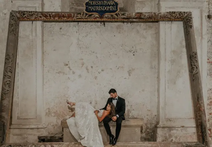 Para młoda w stylizowanych strojach na tle zabytkowych murów. Zastanawiasz się, ile kosztują zdjęcia u fotografa?