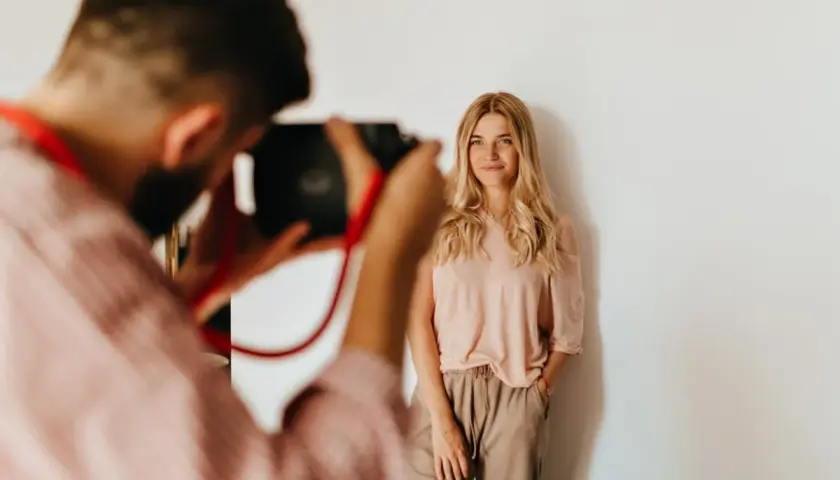 Fotograf robi zdjęcie uśmiechniętej blondynce. Zastanawiasz się, ile fotograf bierze za sesję?