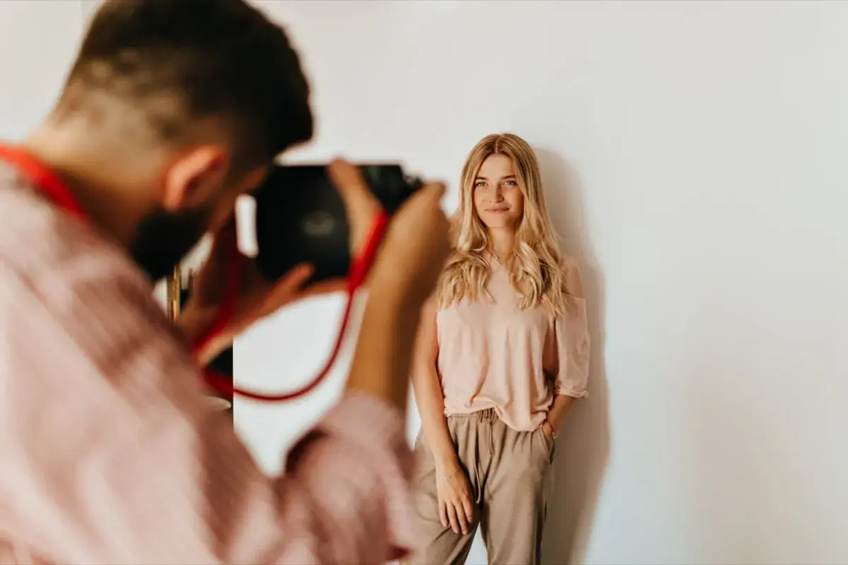Fotograf robi zdjęcie uśmiechniętej blondynce. Zastanawiasz się, ile fotograf bierze za sesję?