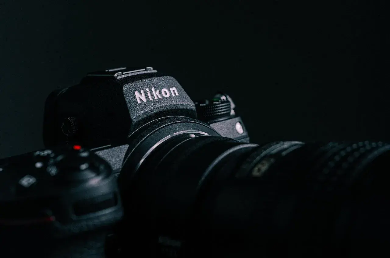 Ciemne zdjęcie aparatu Nikon z obiektywem, z widocznym logo.