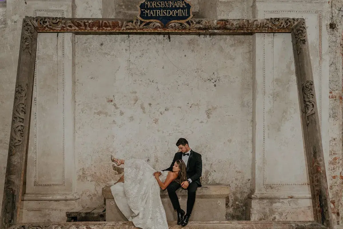 Para młoda w stylizowanych strojach na tle zabytkowych murów. Zastanawiasz się, ile kosztują zdjęcia u fotografa?