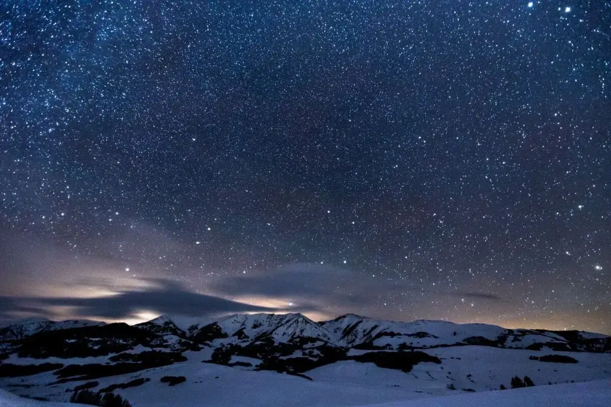 Nocne niebo pełne gwiazd nad ośnieżonymi górami. Dowiedz się, jak zrobić zdjęcie gwiazd iPhonem, by uchwycić takie cuda.